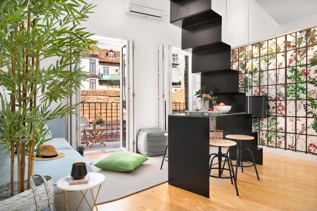 a living room with tables and chairs and a kitchen at Jasmine Loft in Porto