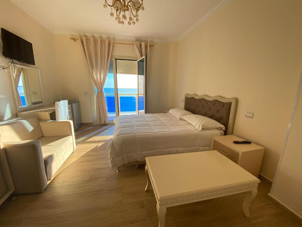 a bedroom with a bed and a couch and a table at Hotel 3 Vellezerit in Durrës