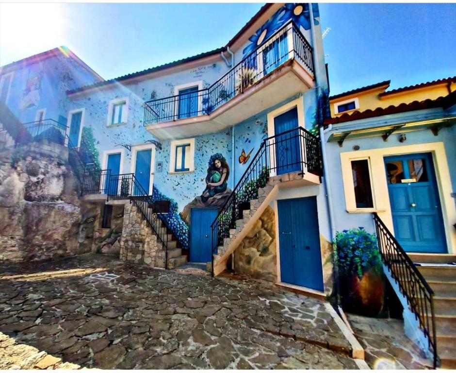 un edificio con puertas azules y escaleras delante en casa vacanza EVERY DAY, en SantʼAngelo le Fratte