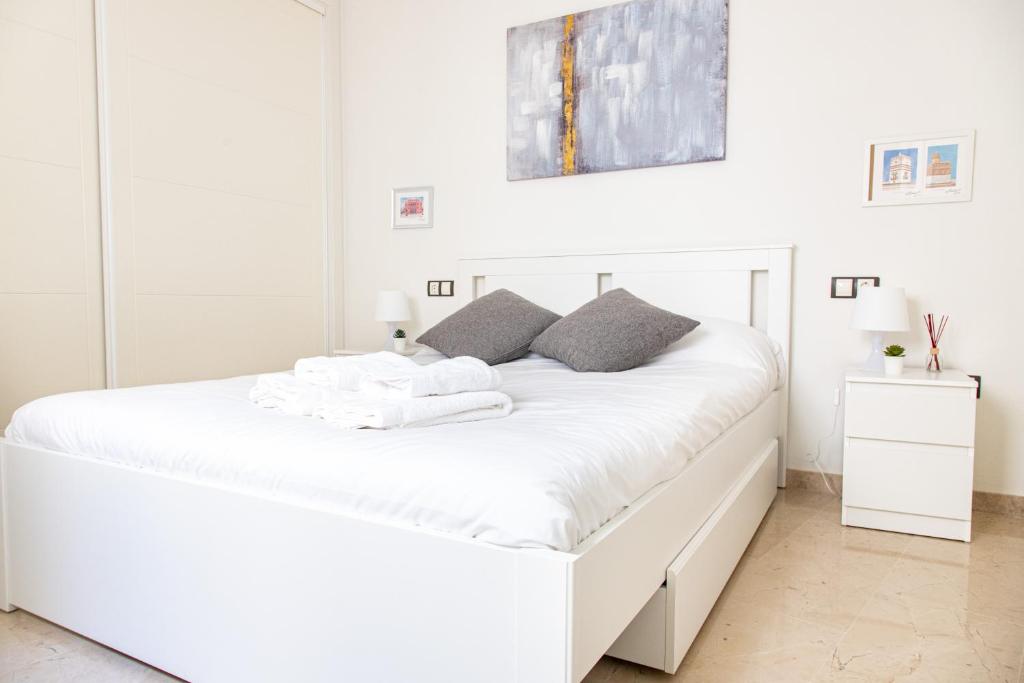 - une chambre blanche avec un grand lit blanc dans l'établissement Apartamento Colon by Cadiz Time, à Cadix