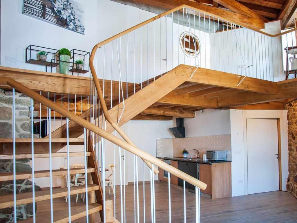 a spiral staircase in a room with a kitchen at A Forxa Casa Ferrador Ribeira Sacra in Sober