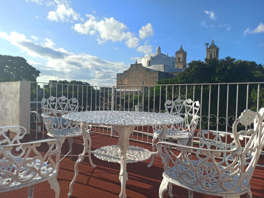 a patio with a table and chairs on a balcony at Hotel Catedral Valladolid Yucatan in Valladolid