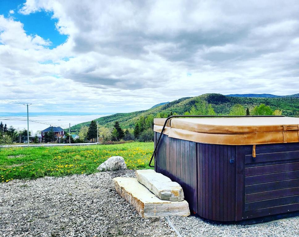 a small wooden shack with a wooden door and a mountain at Maison Accueillante - Spa, fleuve et montagnes! in Petite-Rivière-Saint-François