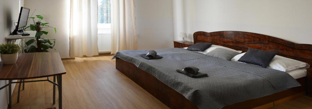 Un dormitorio con una cama con dos sombreros. en Penzion Locanda, en Brno