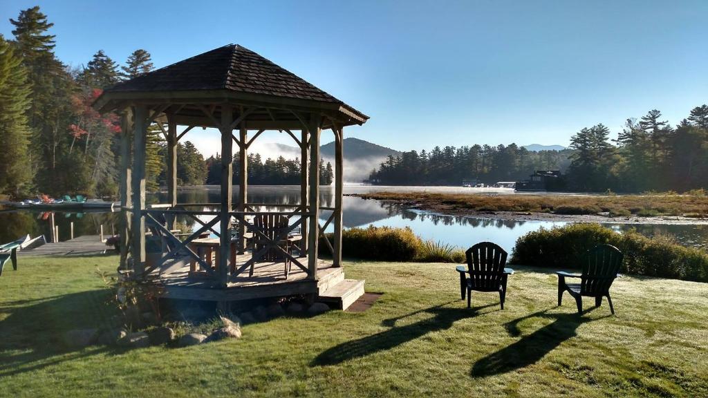 a gazebo with two chairs next to a lake at Wildwood on the Lake in Lake Placid