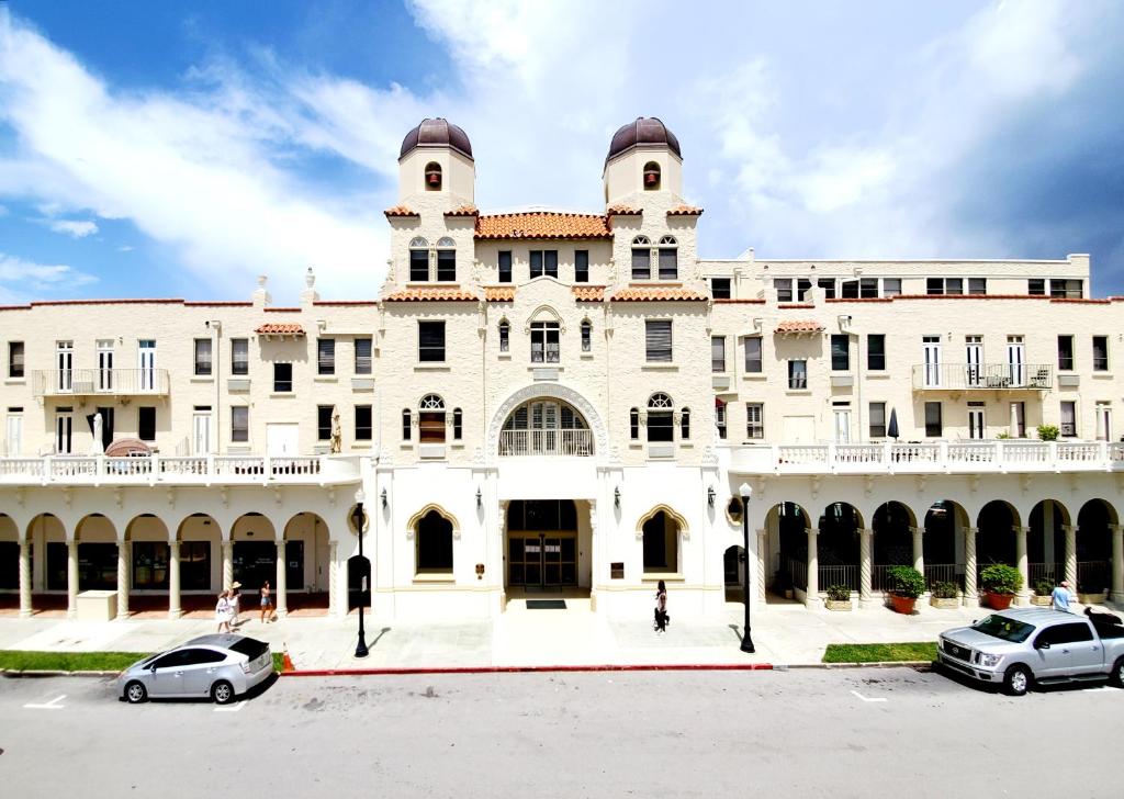 a large white building with cars parked in front of it at Cozy Studio in the Heart of the Palm Beach Island in Palm Beach