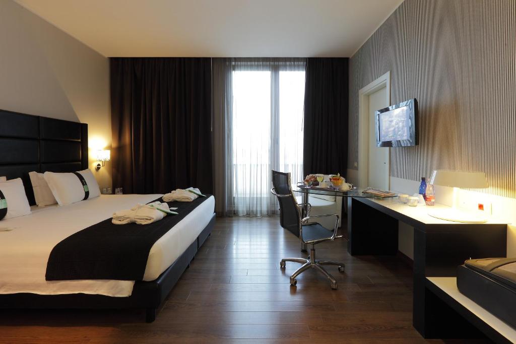 A bed or beds in a room at Holiday Inn Genoa City by IHG