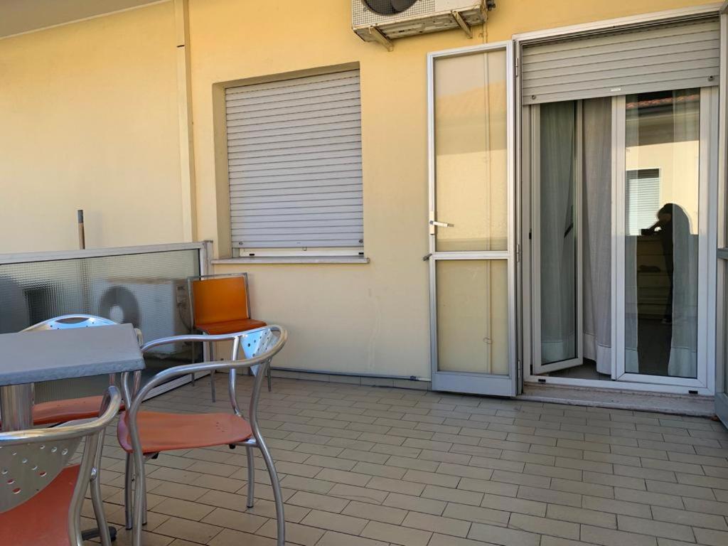 un patio con sillas y mesas y una puerta corredera de cristal en Hotel Piada D'Oro en Riccione