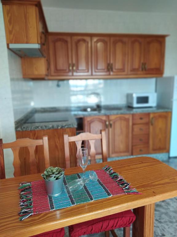 cocina con mesa de madera y copa de vino en apartamentos la villa en San Sebastián de la Gomera