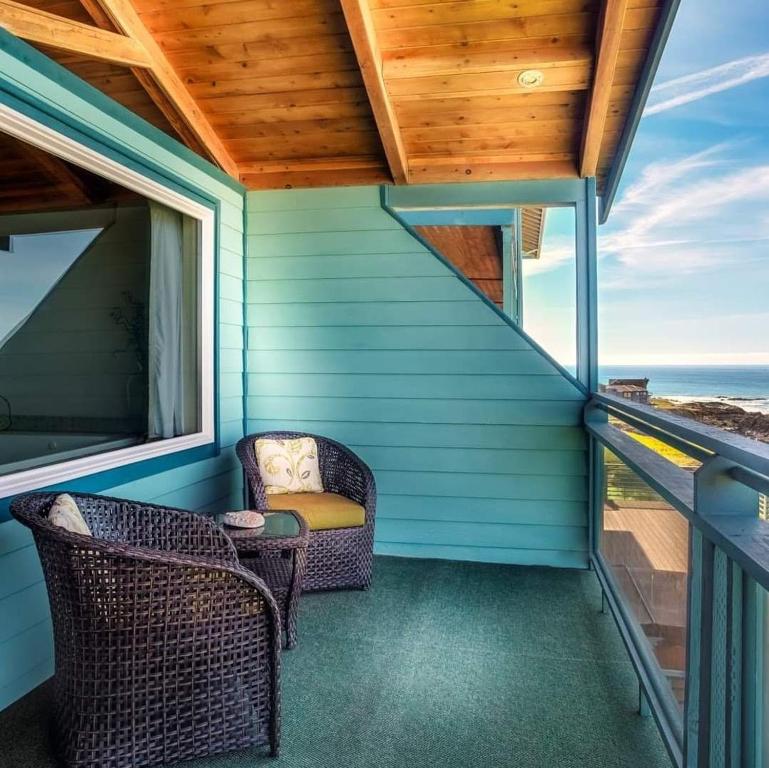 eine Veranda mit 2 Stühlen und einem Fenster in der Unterkunft Inn of the Lost Coast in Shelter Cove