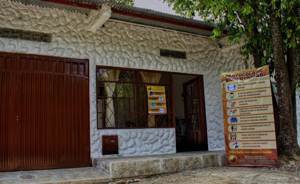 un edificio con una puerta y un cartel delante en Hospederia Sol del Desierto, en Villavieja