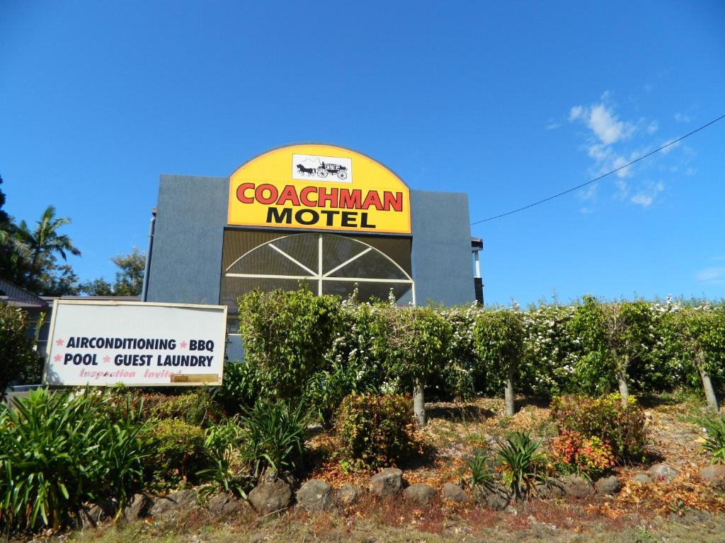 
a large yellow building with a sign on the side of it at Coachman Motel in Toowoomba
