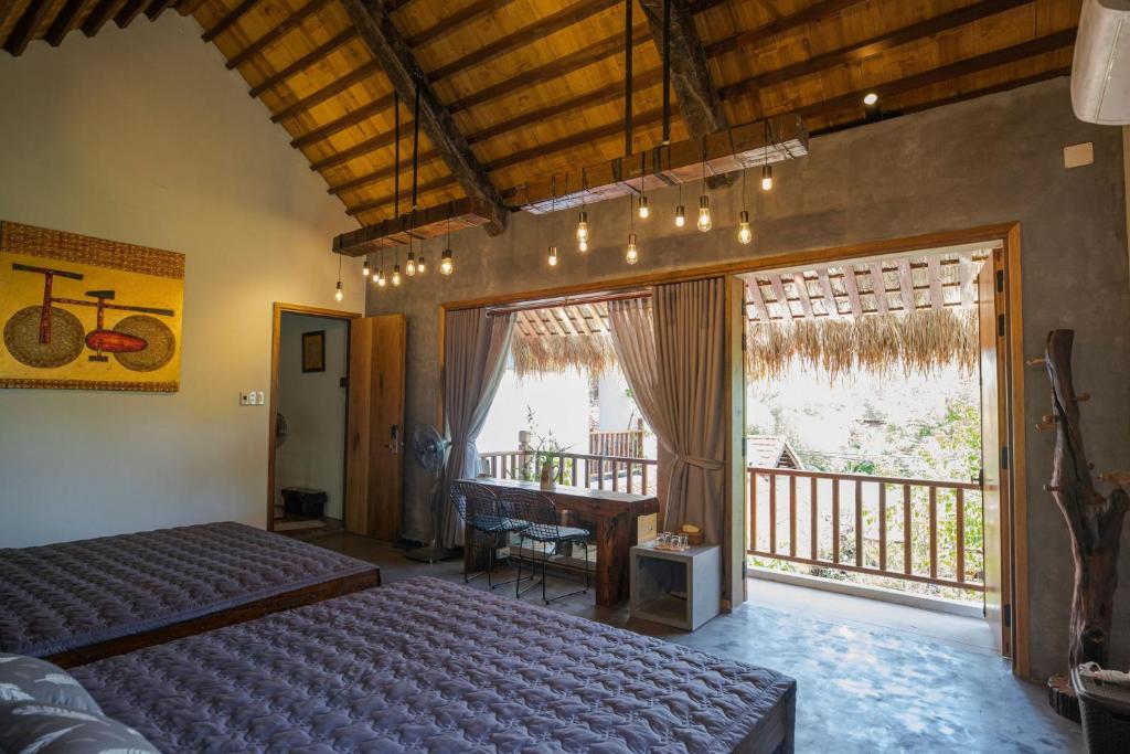 ein Schlafzimmer mit einem Bett, einem Schreibtisch und einem Fenster in der Unterkunft Cat Homestay in Hue