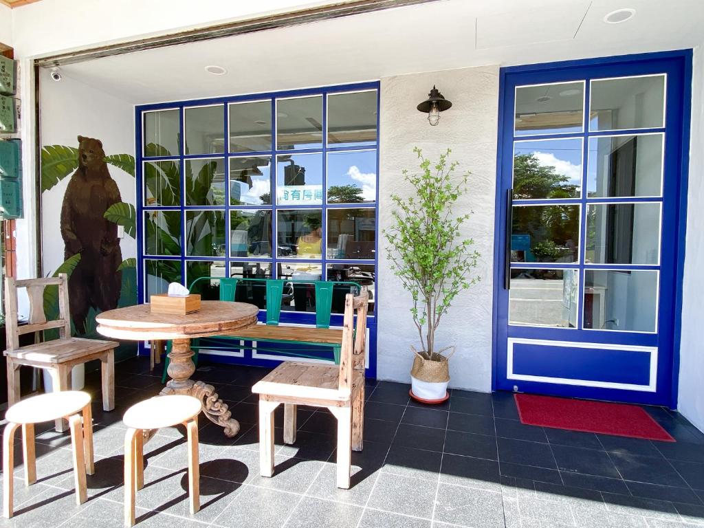 a patio with a table and chairs and a blue door at Kenting Sunhow Inn in Kenting
