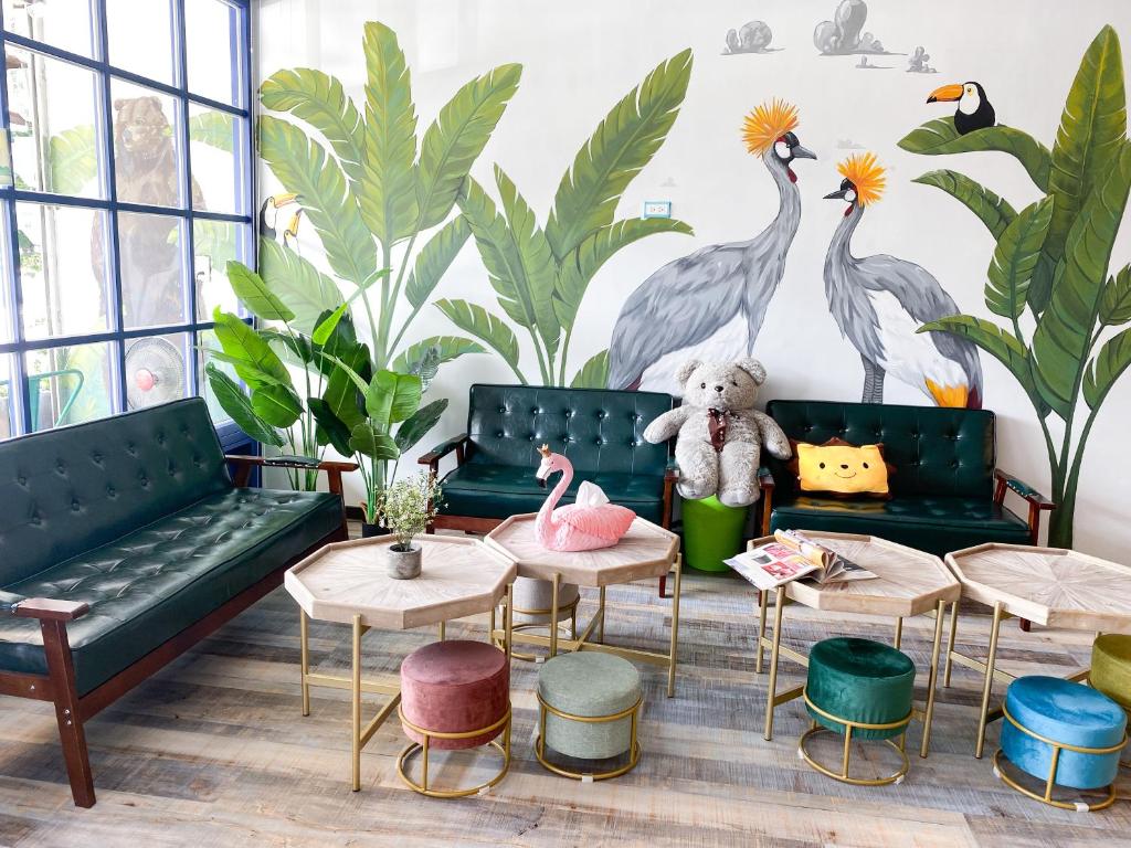 a living room with couches and tables and a mural of birds at Kenting Sunhow Inn in Kenting