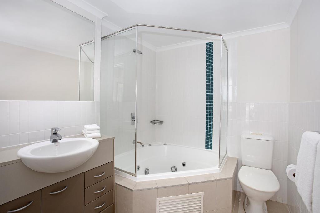 bagno bianco con lavandino e doccia di Mantra Ettalong Beach a Ettalong Beach
