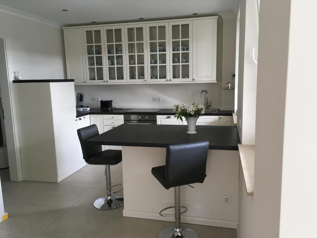 a kitchen with white cabinets and a black counter top at Großzügiges Appartement -ruhig und doch zentral in Odenthal