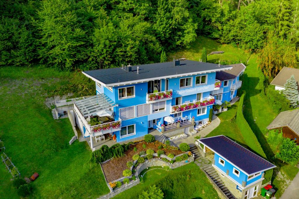 eine Luftansicht eines blauen Hauses mit Garten in der Unterkunft Appartementhaus Lercher in Flattach