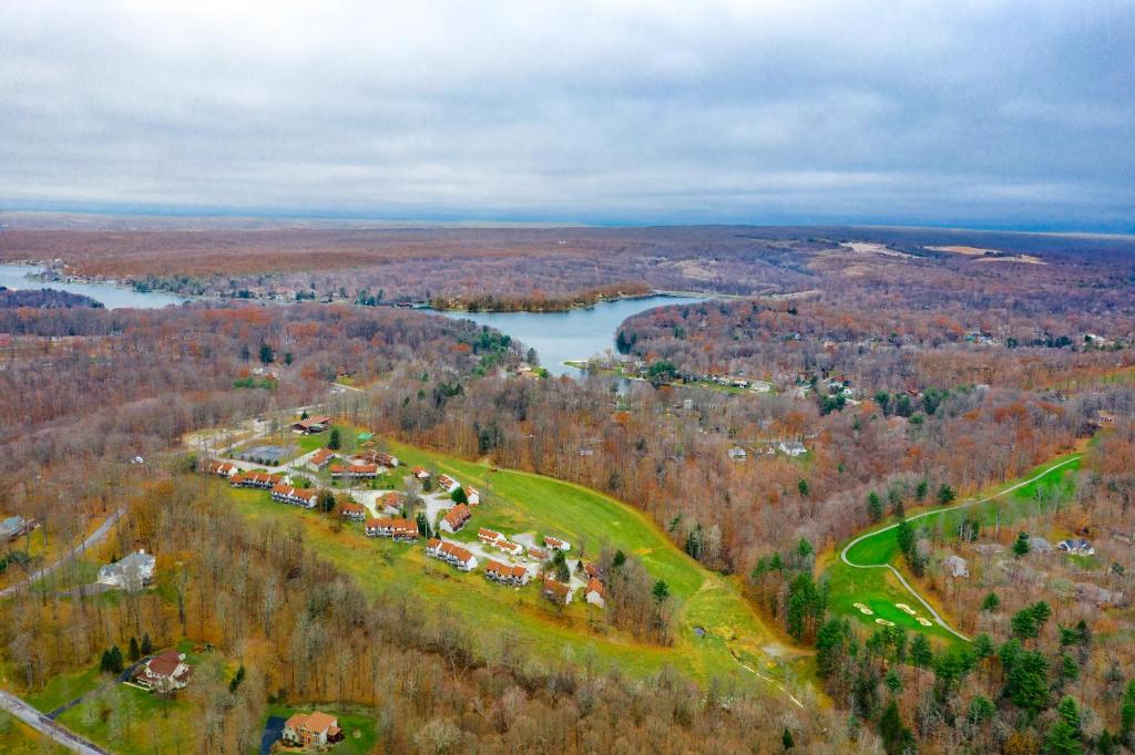 z góry widok na dom na wzgórzu obok jeziora w obiekcie Crown Resorts at Wolf Run w mieście DuBois