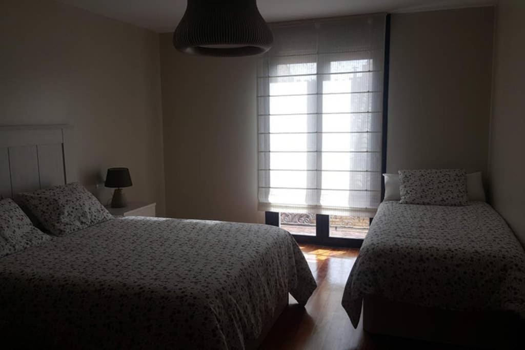1 dormitorio con 2 camas y ventana en Casa Mercedes. Laguardia (Alava), en Laguardia