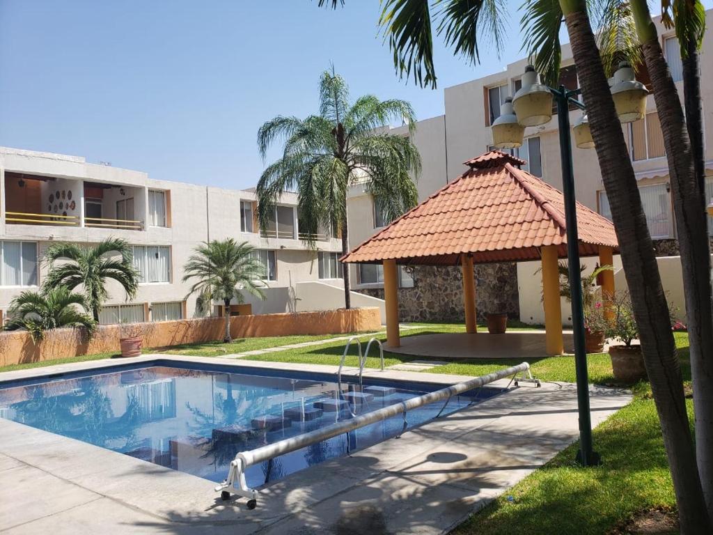 a swimming pool with a gazebo next to a building at Casa en Oasis en Xochitepec in Chiconcuac