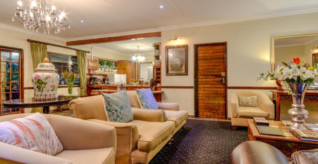 uma sala de estar com um sofá, cadeiras e uma mesa em At Heritage House em St. Lucia