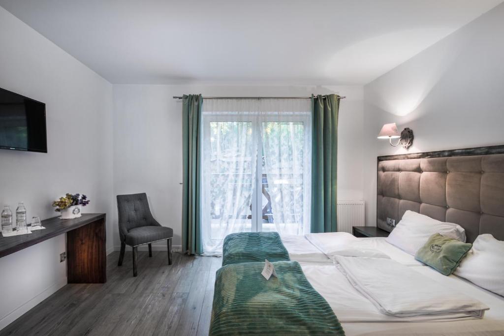 Double bedroom with green throw, tufted headboard and glass doors leading to balcony.