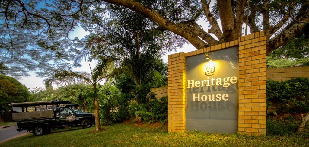 a sign for a heritage house with a jeep in front at At Heritage House in St Lucia