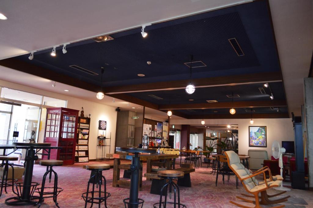 una habitación con mesas y sillas en una biblioteca en Hotel & Resort Kiyomizu Bozanso, en Yamanouchi