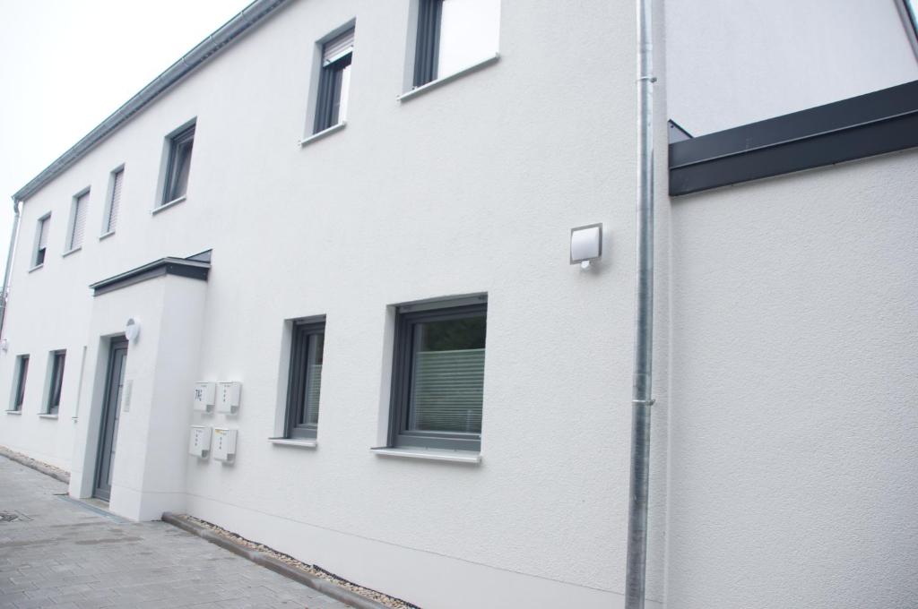 - un bâtiment blanc avec des fenêtres sur le côté dans l'établissement Ferienwohnung Jurastein, à Burglengenfeld