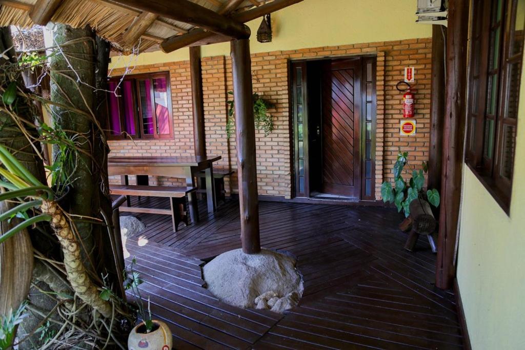 eine Veranda mit einem Außenkamin in einem Haus in der Unterkunft CABANAS PARA ALUGUEL de TEMPORADA EM BOMBINHAS perto da praia in Bombinhas