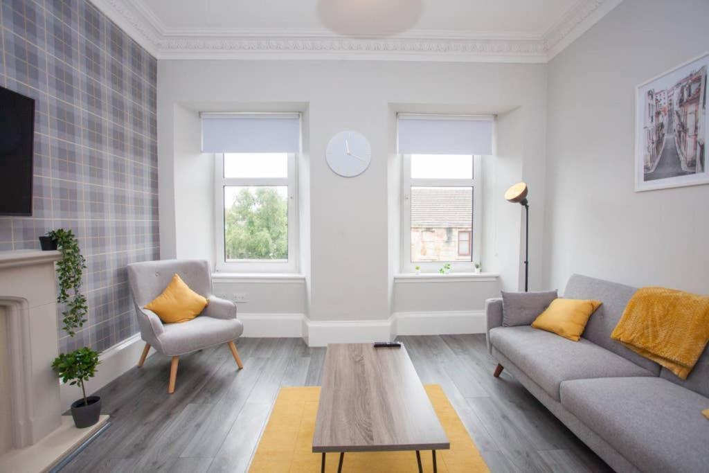 a living room with a couch and a table at The Warwick Apartment in Greenock