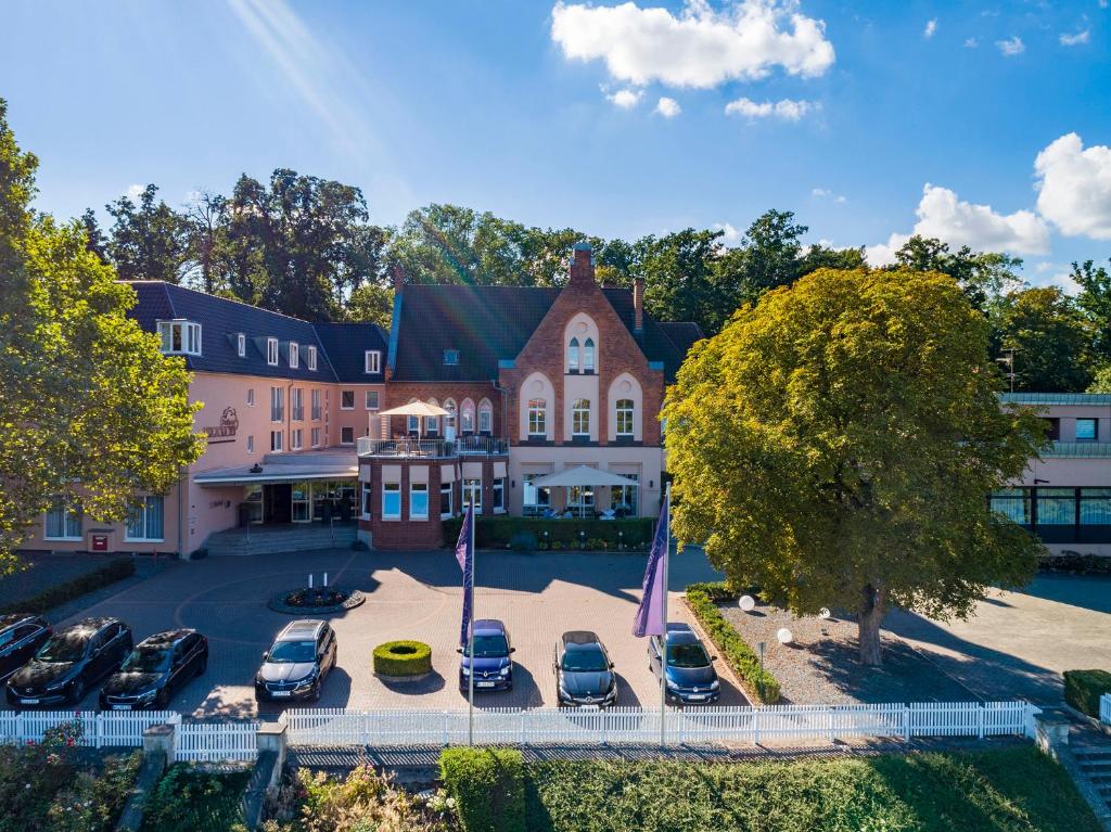 une vue aérienne d'un bâtiment avec des voitures garées sur un parking dans l'établissement Parkhotel Berghölzchen, à Hildesheim