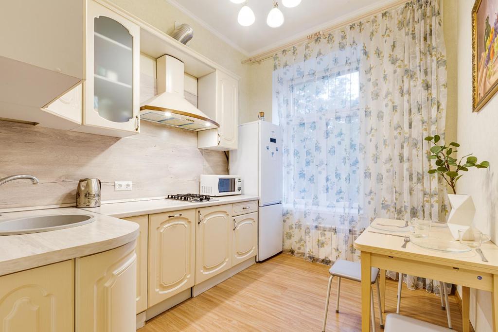 a kitchen with a sink and a refrigerator at Apartment Marata 10 in Saint Petersburg