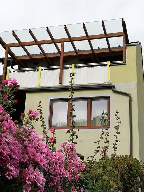 dom z różowymi kwiatami przed nim w obiekcie Apartment Katalin w mieście Murau