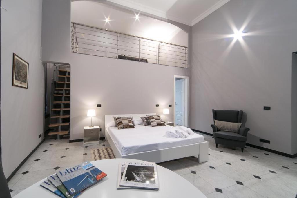 a bedroom with a bed and a table and a chair at Chiossone Suites in Genoa