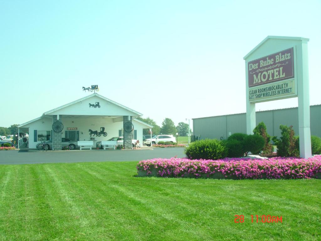 a motel with a sign in front of a yard at Der Ruhe Blatz Motel in Shipshewana