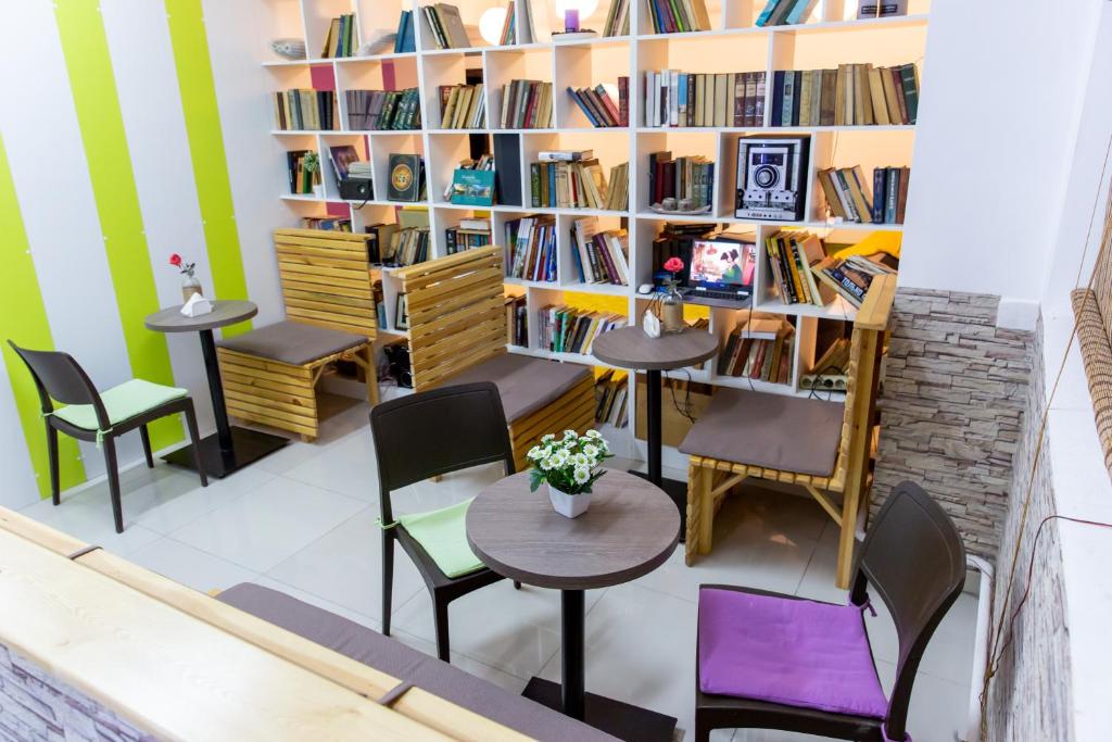 een kamer met tafels en stoelen en boekenplanken bij Хостел 689CapsuleHotel&Coffee in Alma-Ata