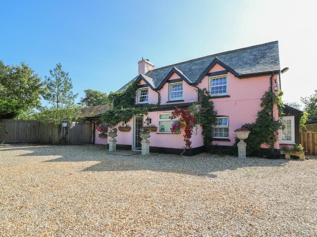 ein rosafarbenes Haus mit Kieseinfahrt in der Unterkunft Park House in Llandrindod Wells