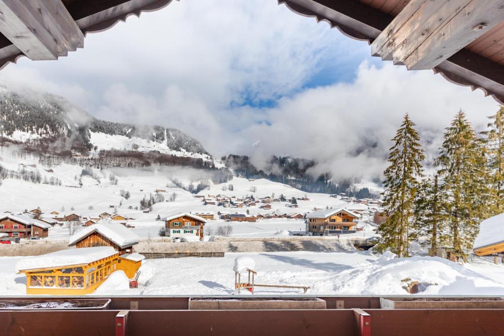 Blick auf ein schneebedecktes Dorf in den Bergen in der Unterkunft Apart Solaria - Wohnungen in Au-Schoppernau in Au im Bregenzerwald