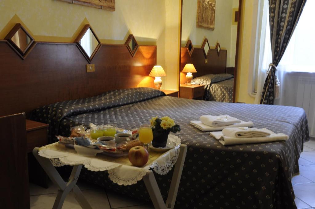 a hotel room with a tray of food on a bed at Hotel Farini in Rome