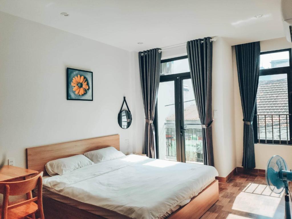 ein Schlafzimmer mit einem Bett und einem großen Fenster in der Unterkunft Cozy Apartment in Đà Nẵng