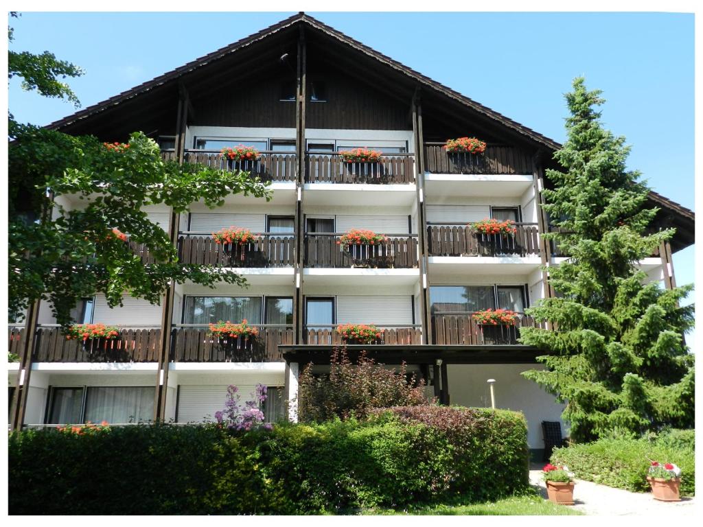 un edificio de apartamentos con macetas en los balcones en Gästehaus Huber - Hotel Garni, en Bad Füssing