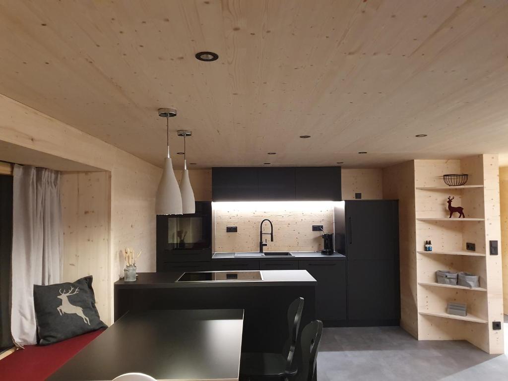 a kitchen with black cabinets and a black counter top at Chaletwohnung Dorfbrunnen in Oy-Mittelberg