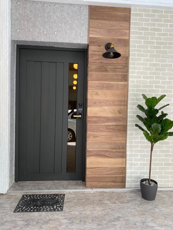 a black front door of a house with a potted plant at 逢甲菓子宿 in Taichung