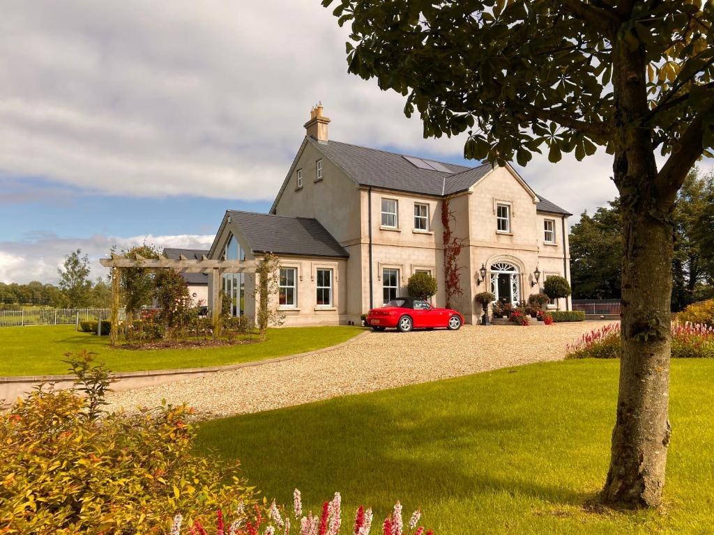 a house with a red car parked in front of it at Ashbrook House B&B in Aughnacloy
