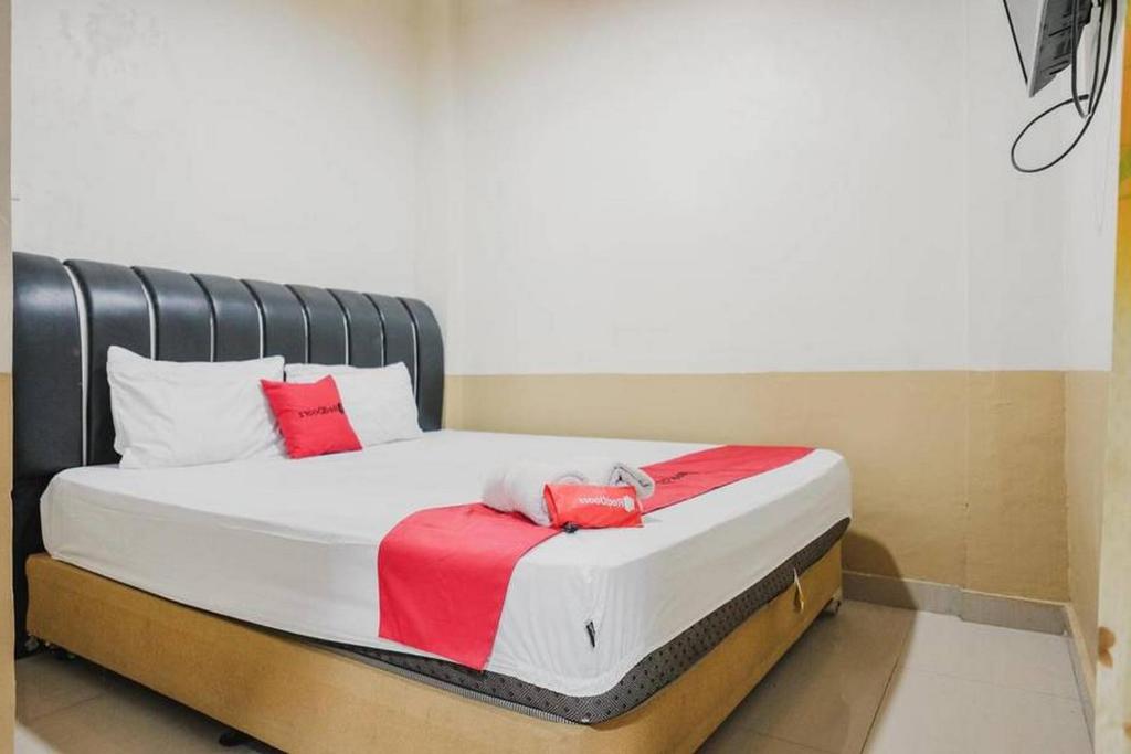 a bed in a room with red pillows on it at RedDoorz @ Jalan STM Medan in Medan