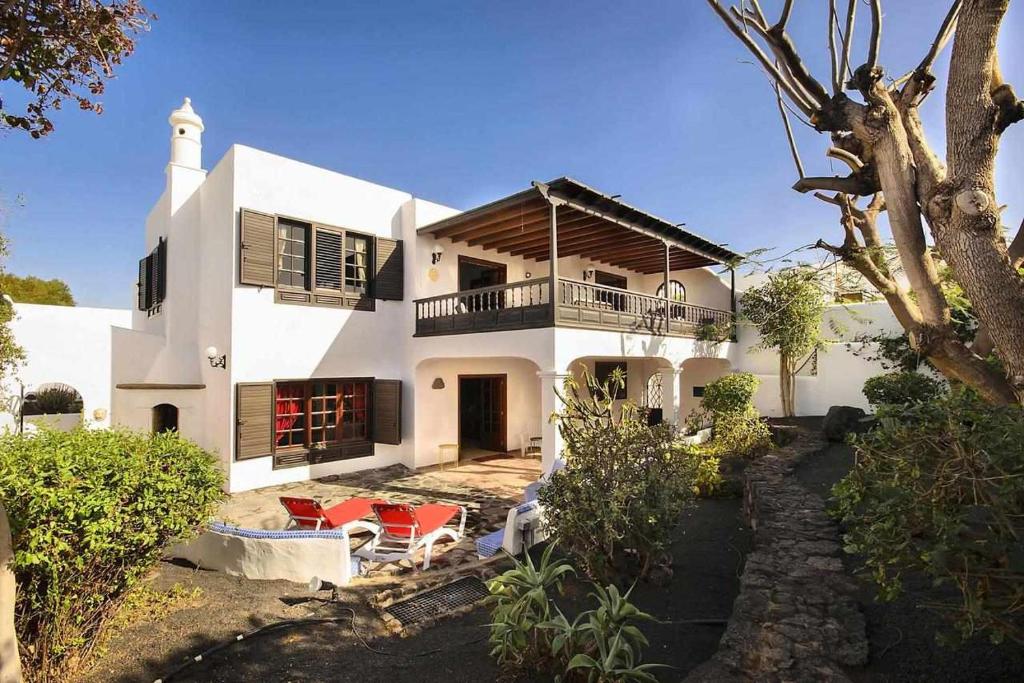 a white house with a porch and a balcony at Casa Jardin ideal para familias in Arrecife