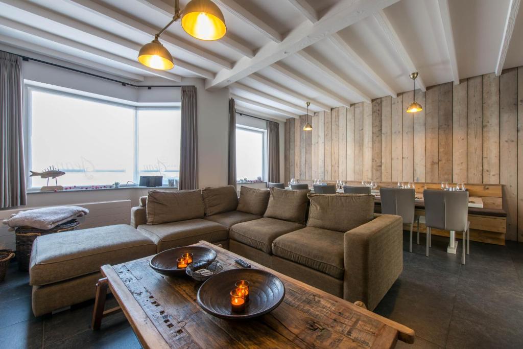 een woonkamer met een bank en een tafel bij Maison Jean in Nieuwpoort