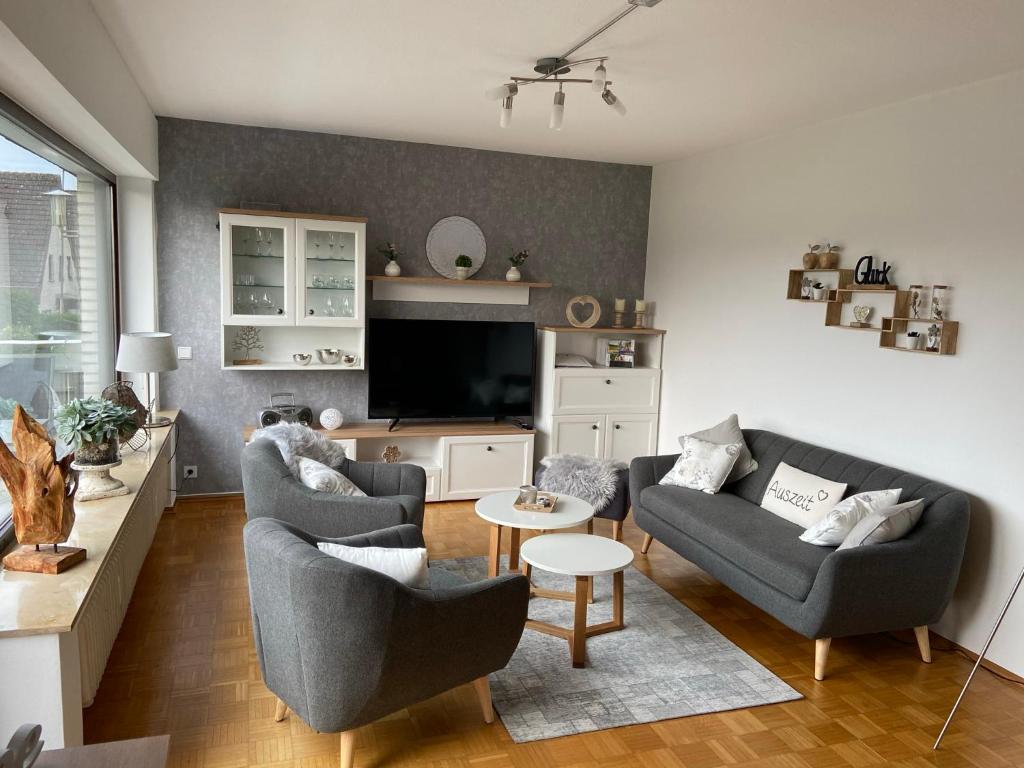 een woonkamer met 2 banken en een tv bij Ferienwohnung Baumberger-Auszeit in Coesfeld